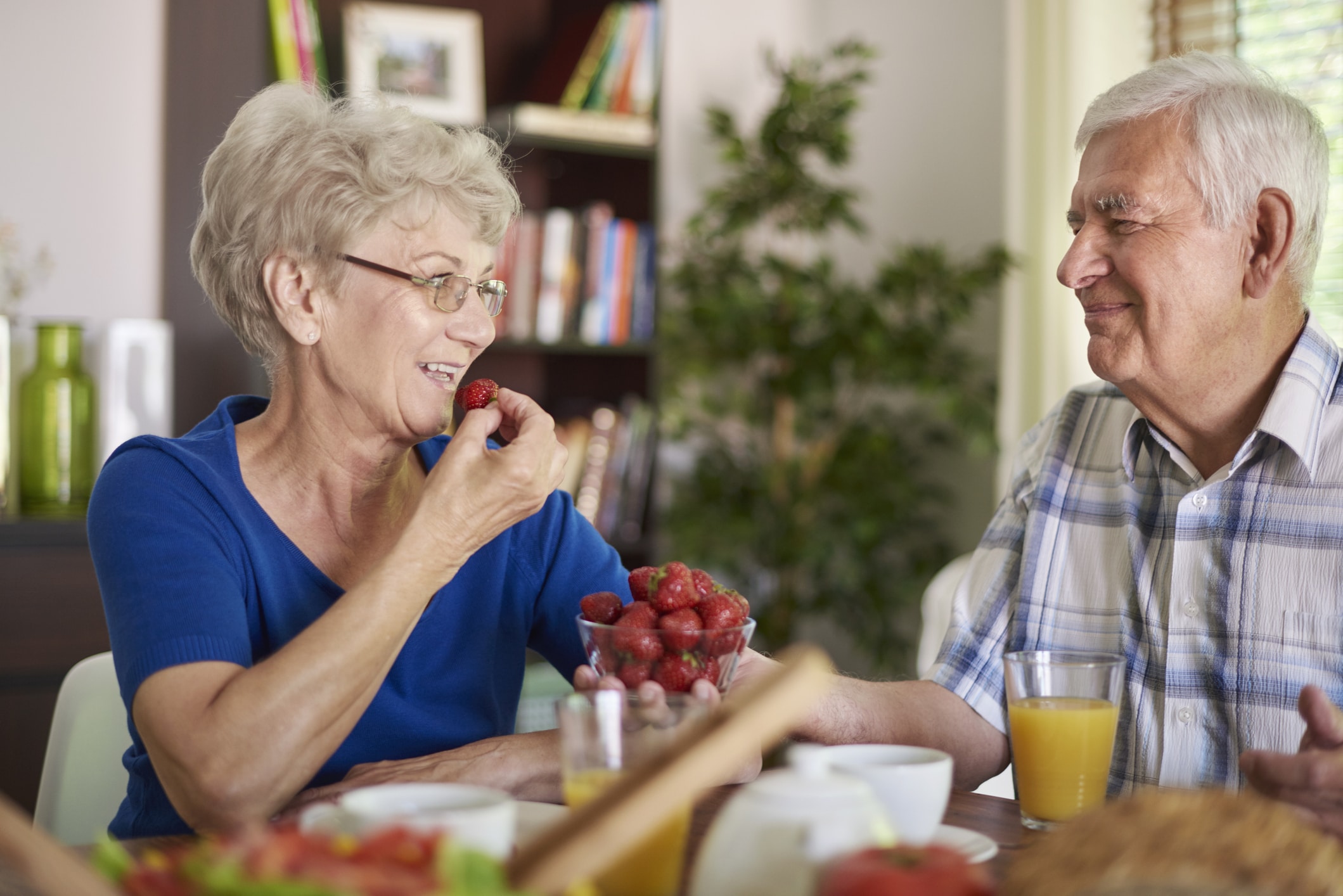 two people sitting at a table eating food