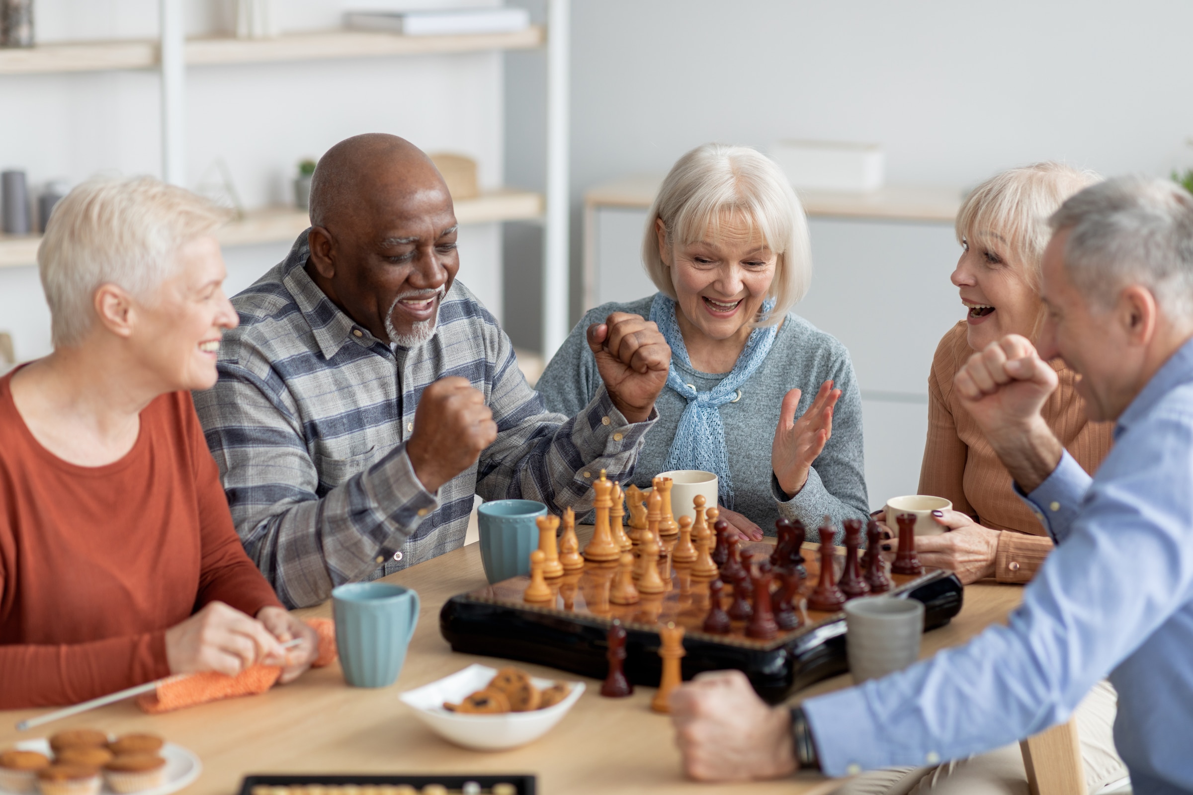 a group of people sitting at a table playing chess