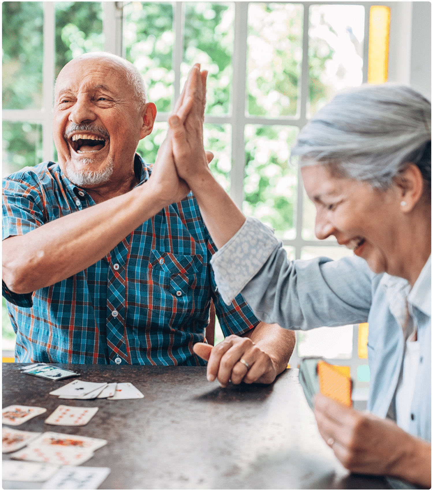 Group of seniors enjoying a lively card game, showcasing the vibrant community atmosphere at One Lincoln Park in Kettering, OH.