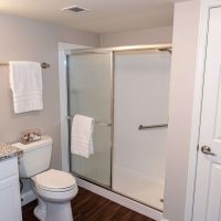 Modern Bathroom With Granite Countertops And Walk-in Shower At One Lincoln Park Senior Living Community In Dayton, Ohio.